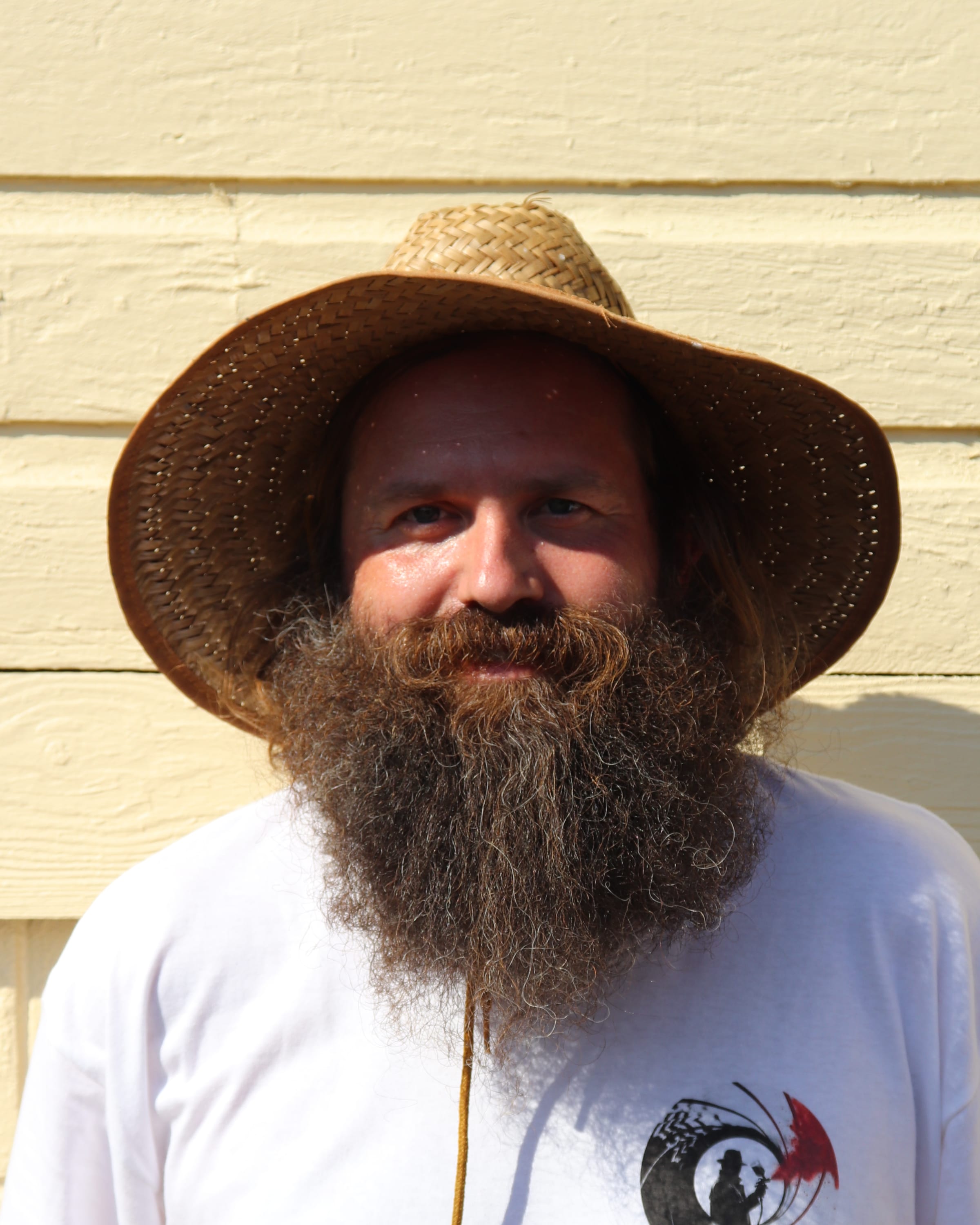 Portrait of a Paint Gunners painter in a straw sun hat and branded shirt