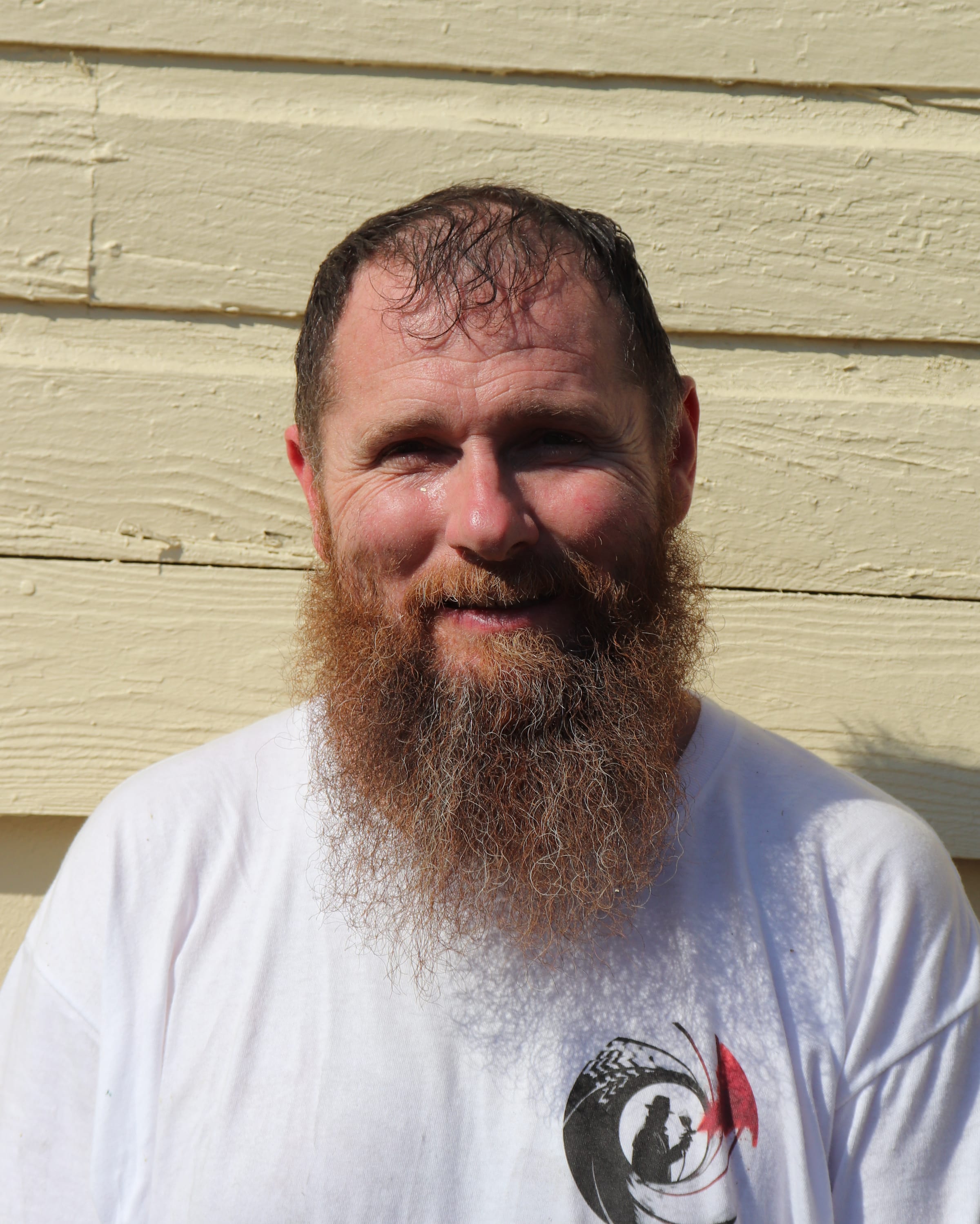 Portrait of a bearded Paint Gunners crew member in a branded shirt